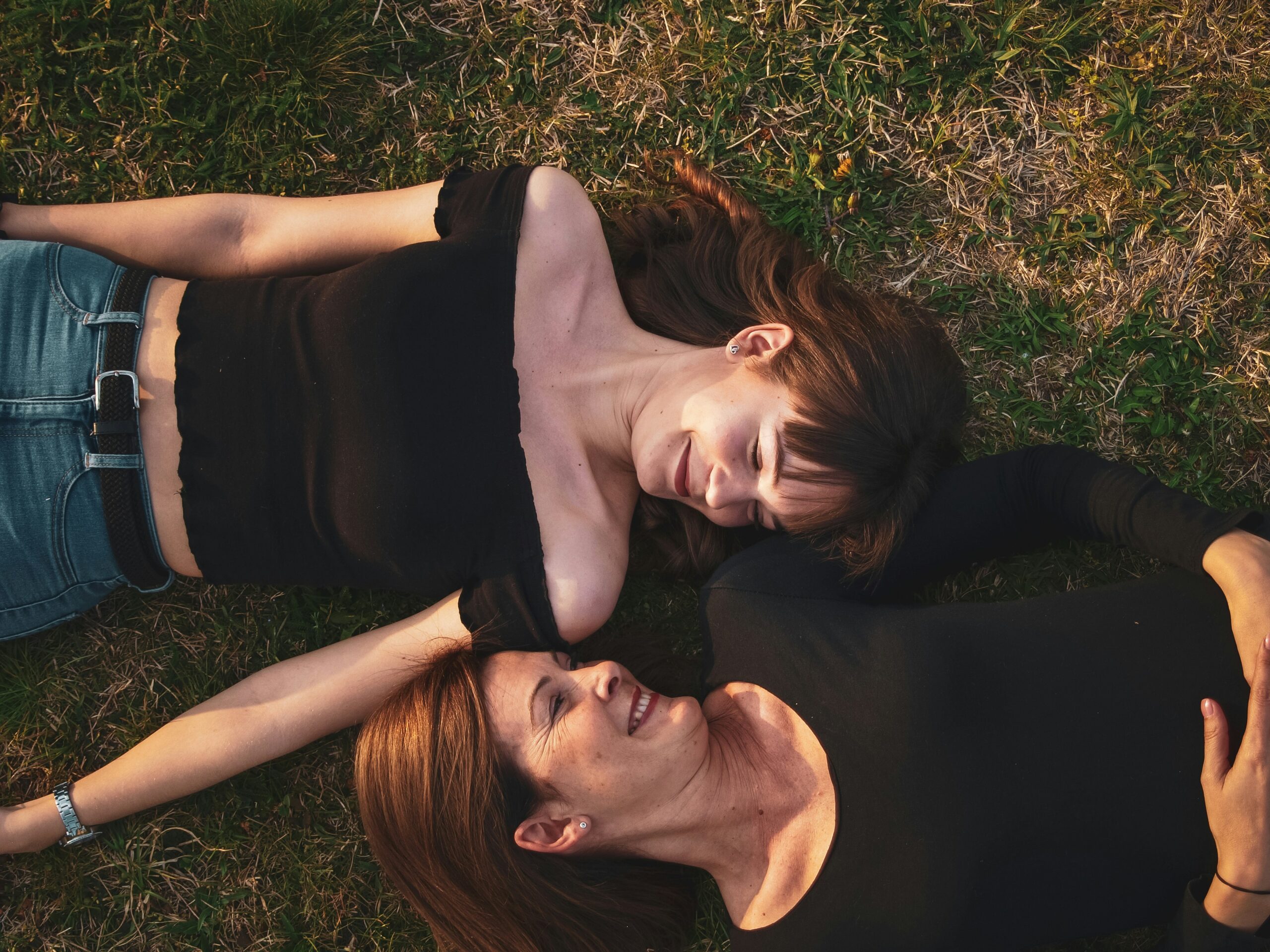 two girls are lysing on the ground and looking at each other