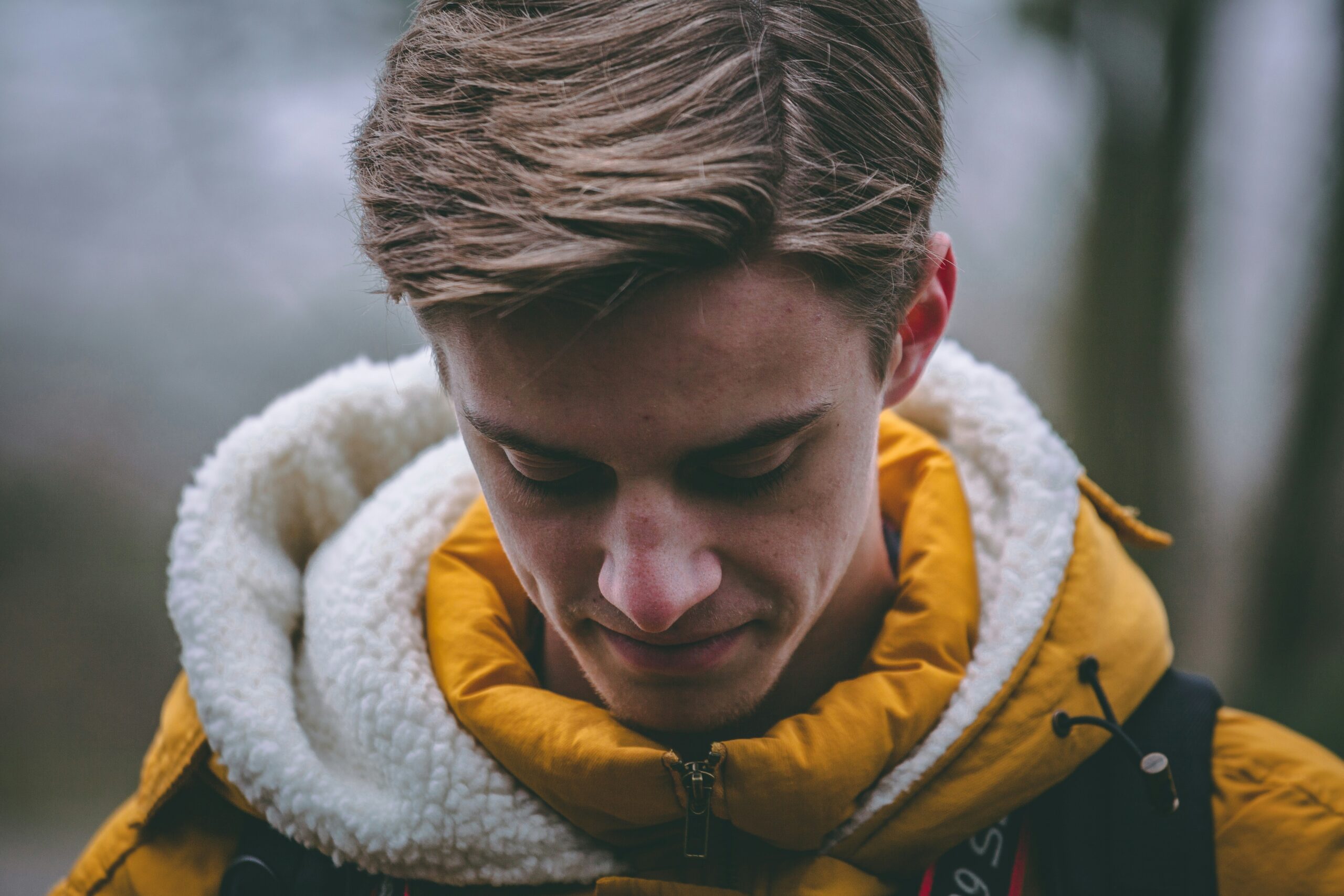 A guy in yellow hoodie looking down